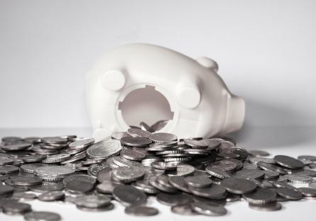 Quarters spilling out of a broken piggy bank