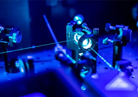 stock image of a laser reflecting through a lens