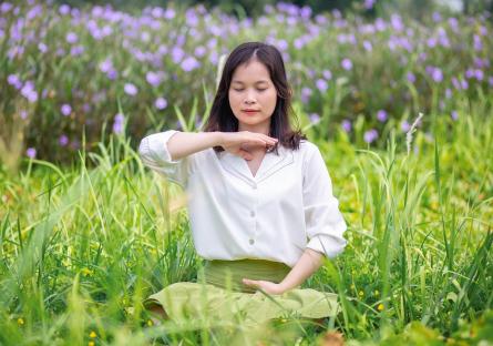 Woman meditating in a grassy field