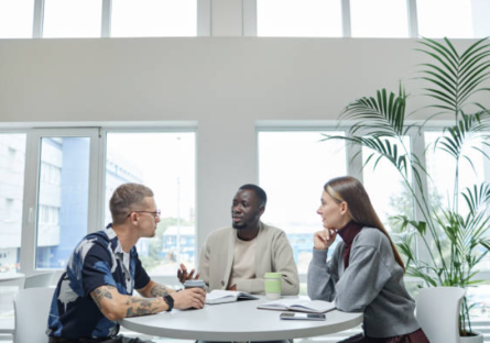 Three people sitting around an office table
