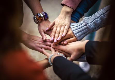 A circle of hands touching in the middle