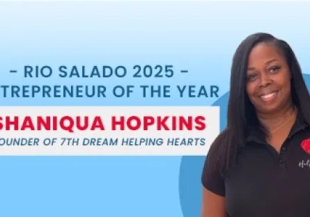 Shaniqua Hopkins, founder of 7th Dream Helping Hearts, stands smiling in front of a blue background. She wears a black polo shirt with a red heart logo on the left side. Text beside her reads: “Rio Salado 2025 Entrepreneur of the Year – Shaniqua Hopkins, Founder of 7th Dream Helping Hearts.”