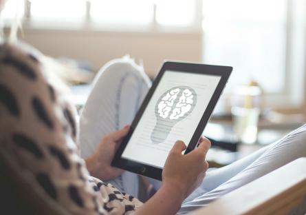 Woman using tablet with image of brain on it