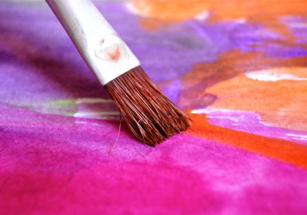 Brush painting magenta on a canvas