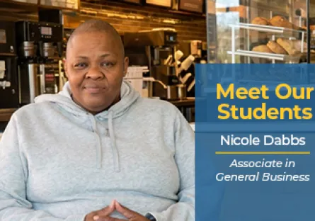 Nicole Dabbs sits inside a café wearing a gray hoodie. A blue graphic beside her reads, “Meet Our Students, Nicole Dabbs, Associate in General Business.”