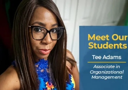 A close-up selfie portrait of Tee Adams, a Black woman with long straight brown hair and black framed glasses, wearing a blue floral top. A dark blue graphic overlay in the bottom-right corner features white and yellow text stating: "Meet Our Students | Tee Adams | Associate in Organizational Management".