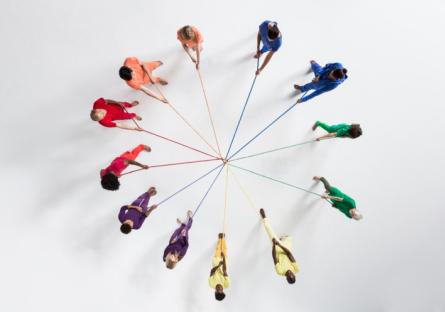 A circle of people holding strings connecting each other