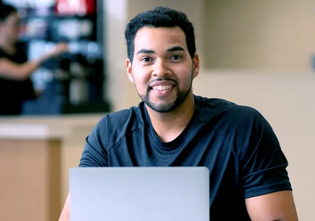 male with computer smiling 