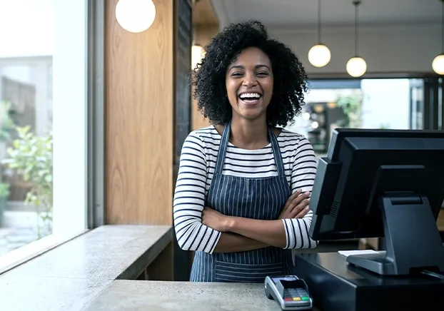 female folding her arms smiling in front of register