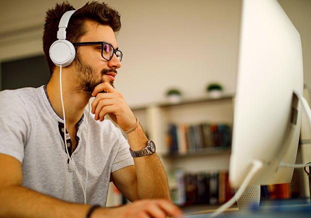 Student in front of computer with headphones