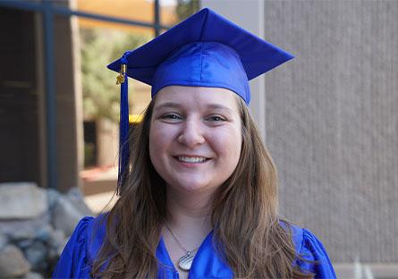 photo of Rheanan Heller in her cap and gown outside Rio Salado College Tempe location.